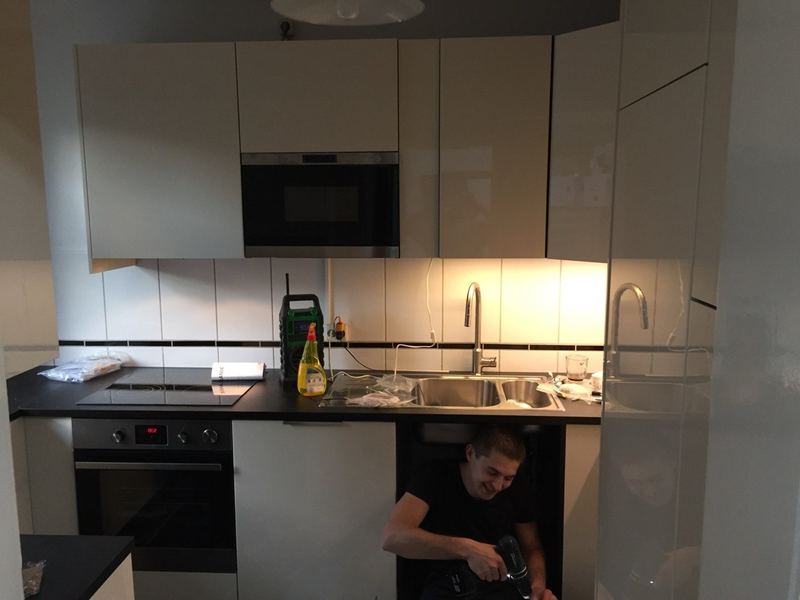 Klempner bei Sanitär-Arbeit unter der Spüle in Hamburg